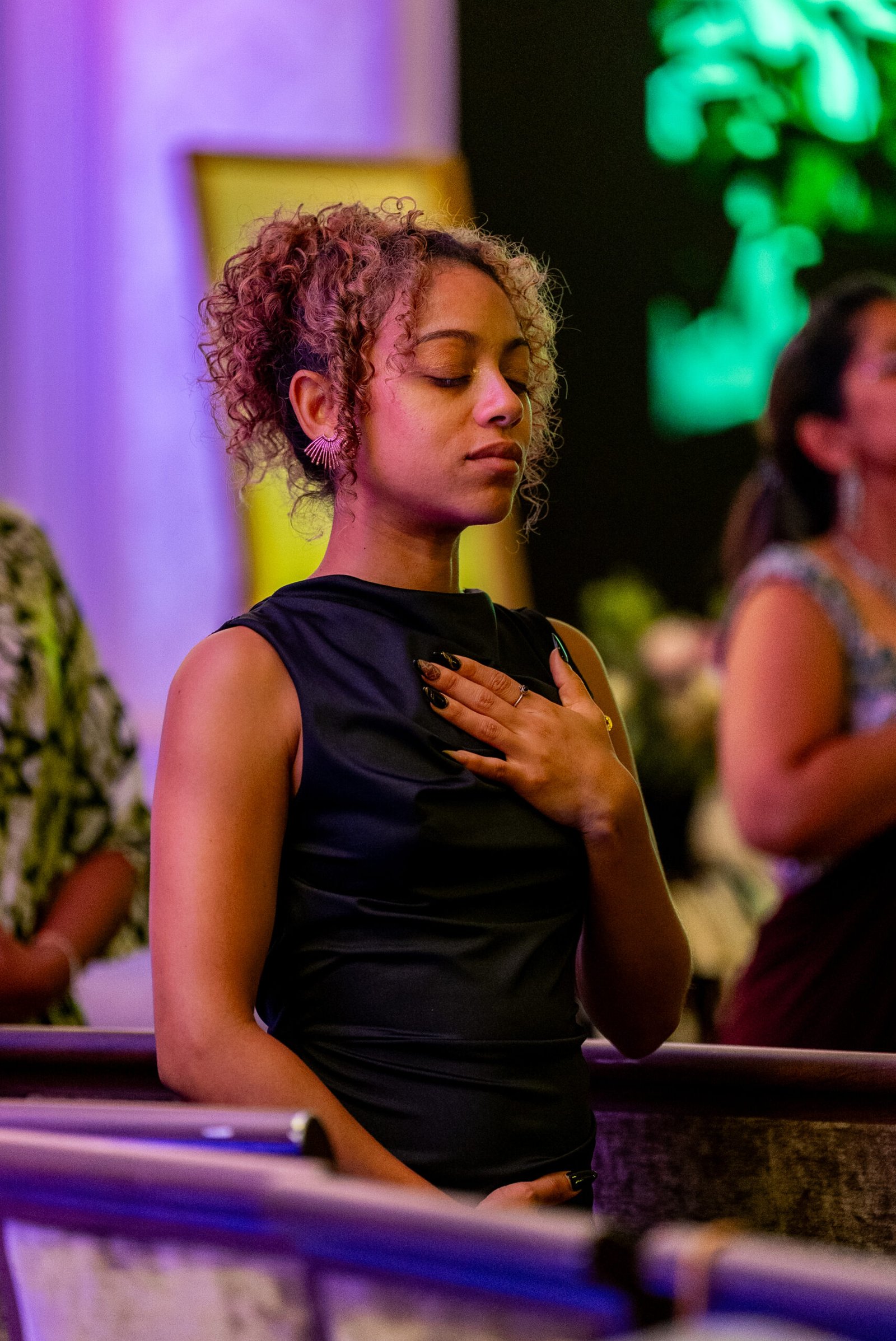 Dorianne Etive closing her eyes with one hand on her heart